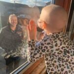 Bimba di 4 anni malata di tumore saluta il papà dalla finestra: l’immagine simbolo della lotta al Covid-19