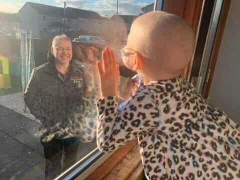 Bimba di 4 anni malata di tumore saluta il papà dalla finestra: l’immagine simbolo della lotta al Covid-19