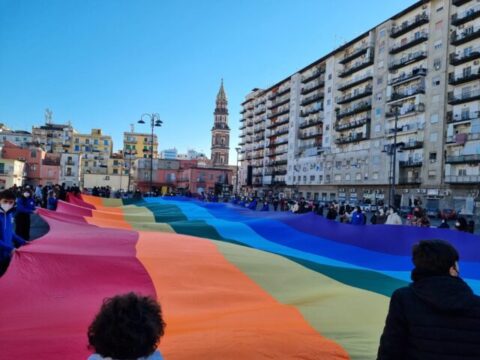 Un abbraccio simbolico con maxi bandiera della pace a piazza Mercato, per la chiesa vandalizzata