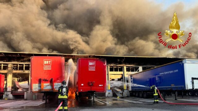 Vasto incendio all’interno del deposito di un corriere BRT, alte colonne di fumo